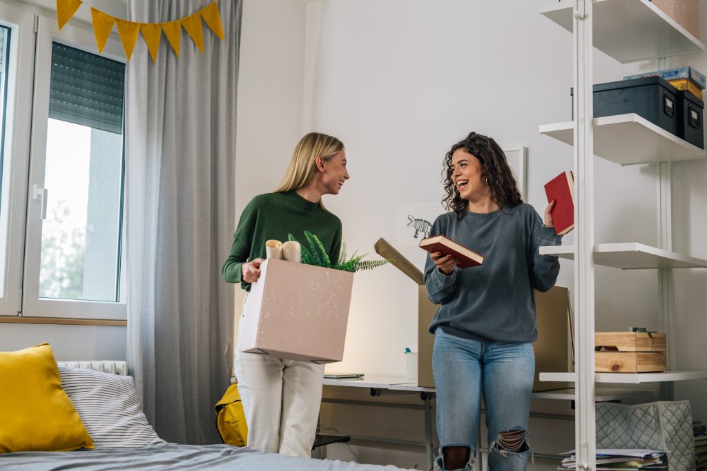 Two college women unpacking boxes in a college rental apartment