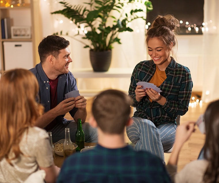 A group of college students playing cards in an apartment